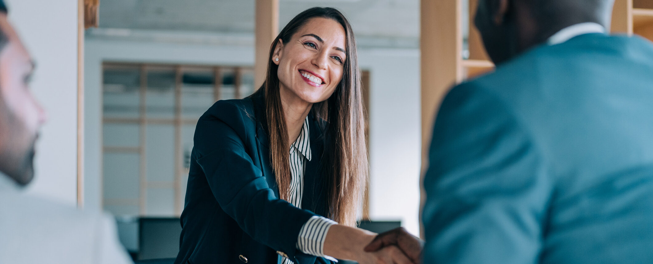 Two colleagues in an office shake hands.